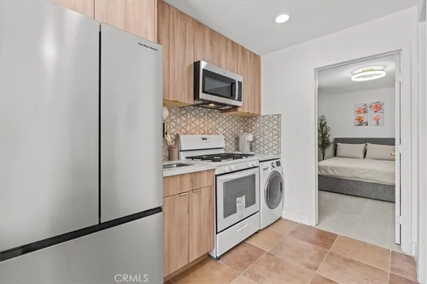 a kitchen with stainless steel appliances granite countertop a stove a microwave and a refrigerator
