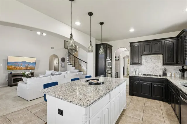 a kitchen with granite countertop a sink a counter top space appliances and cabinets