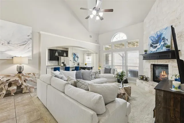 a living room with furniture a fireplace and a chandelier