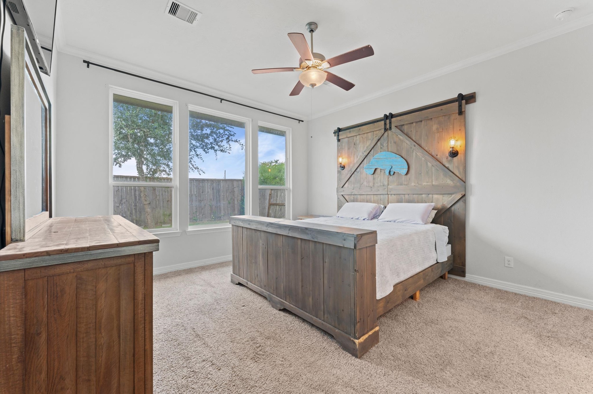 3510 Whitman Drive Rosharon, TX 77583 - Photo 8 of 25 This primary bedroom features large windows for natural light, soft carpet and a ceiling fan. The neutral carpet and walls create a warm and inviting atmosphere.