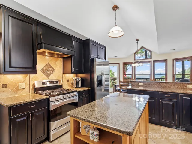 a kitchen with stainless steel appliances granite countertop a stove a sink and a microwave