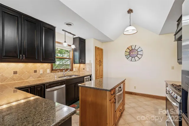 a kitchen with stainless steel appliances a sink stove and cabinets