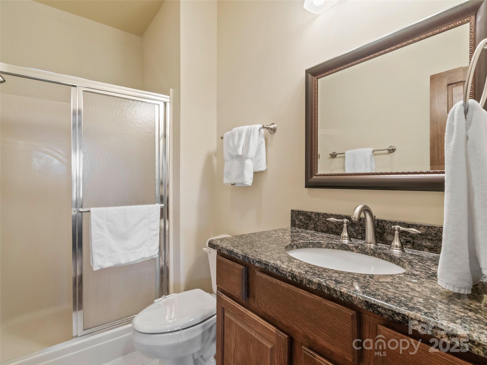 91 Brandy Run Road Burnsville, NC 28714 - Photo 35 of 48 a bathroom with a granite countertop sink mirror vanity and toilet