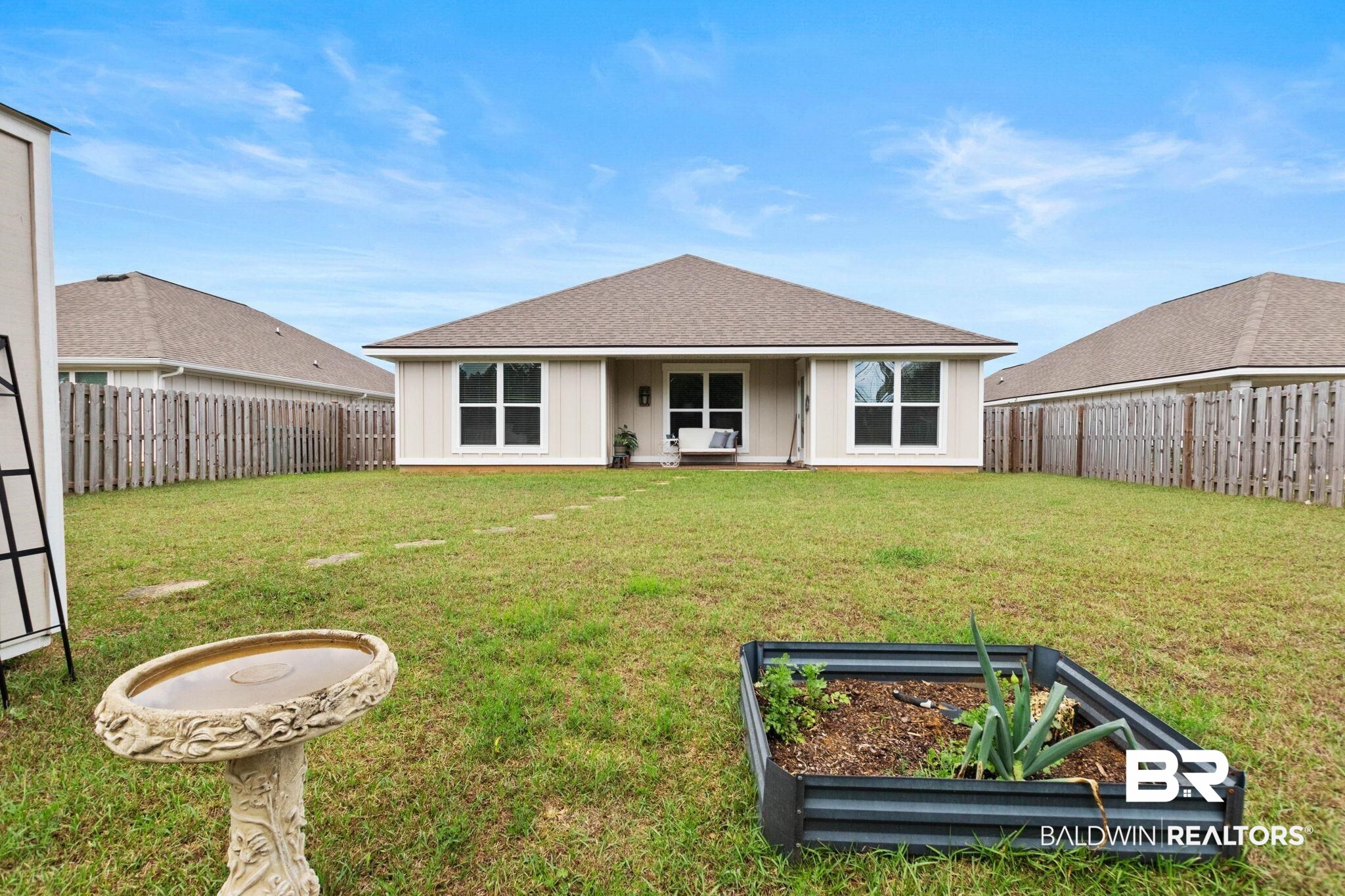 1203 Hayward Loop Foley, AL 36535 - Photo 32 of 41 Back of house featuring a garden, a shingled roof, a fenced backyard, and a patio