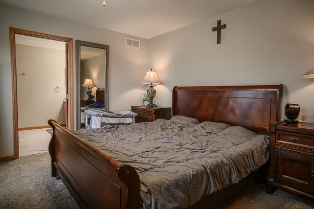 a bedroom with a bed and dresser with mirror