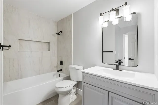 a bathroom with a sink a toilet a mirror a bathtub and shower