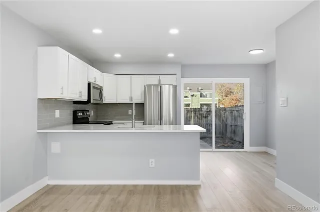 a view of kitchen with stainless steel appliances granite countertop cabinets and wooden floor