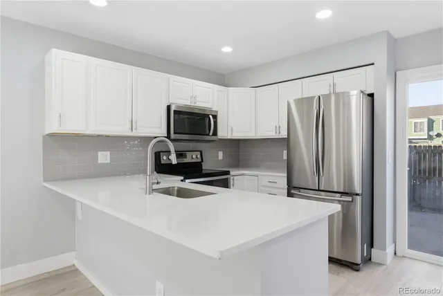 a kitchen with stainless steel appliances a refrigerator microwave and sink