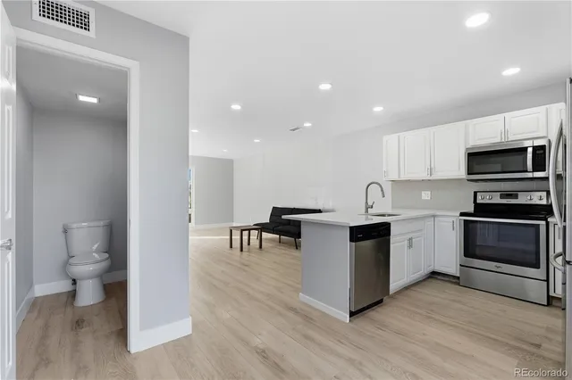 a kitchen with sink a microwave and cabinets