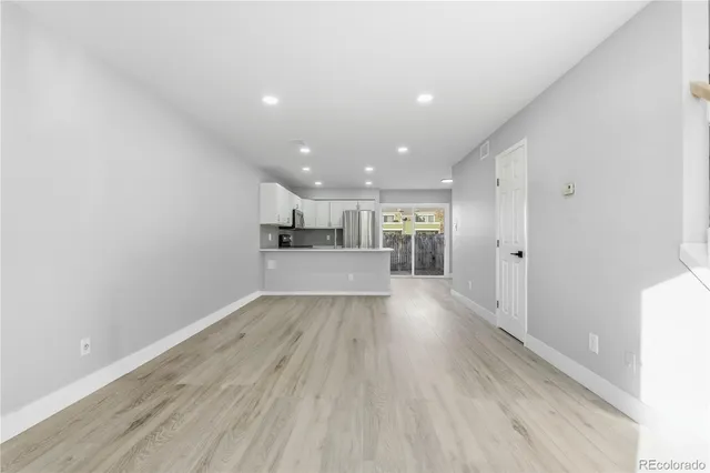 a view of a kitchen with a sink and wooden floor