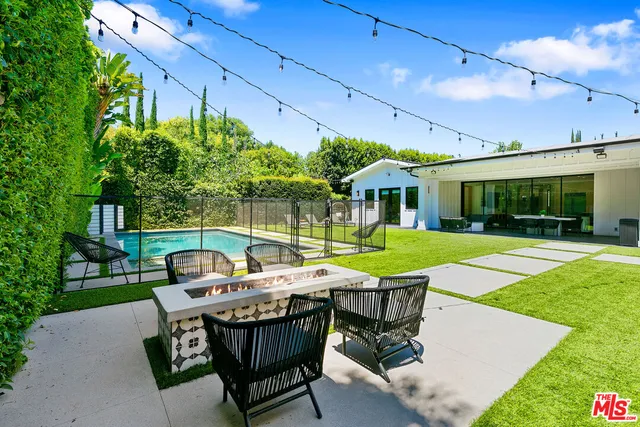 a view of a patio with table and chairs potted plants with wooden floor and fence