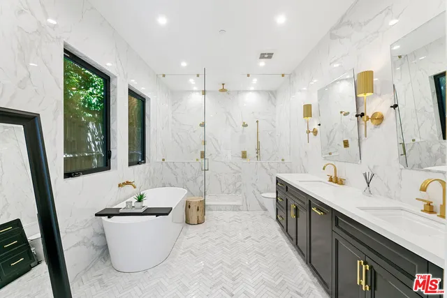 a spacious bathroom with a double vanity sink a mirror and a bathtub