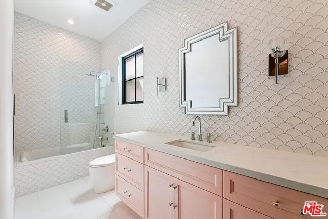 a bathroom with a granite countertop toilet sink and mirror