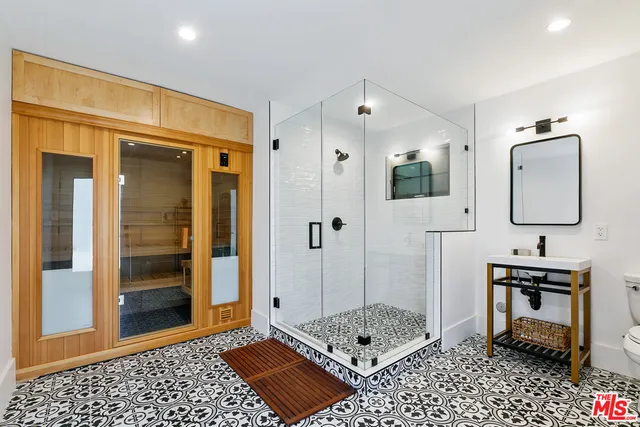 a bathroom with a sink a toilet and shower