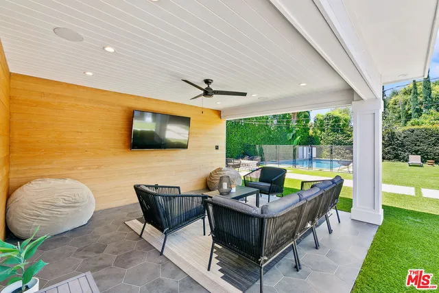 a living room with patio furniture and a flat screen tv