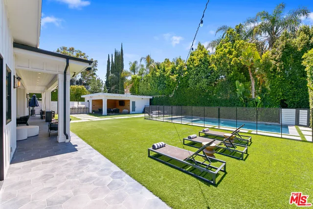 a view of a backyard with swimming pool