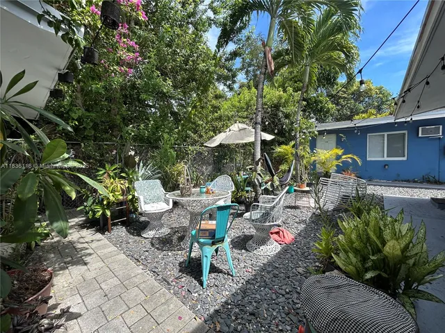a view of a backyard with plants and chairs