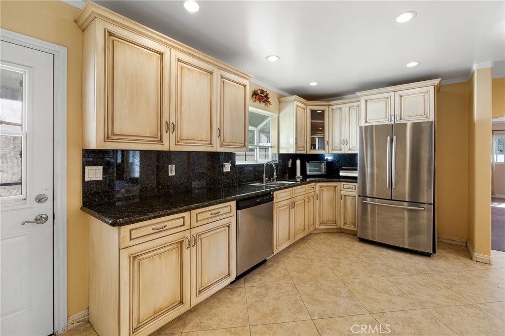 6249 Delfino Street Tujunga, CA 91042 - Photo 18 of 40 a kitchen with granite countertop a refrigerator sink and cabinets