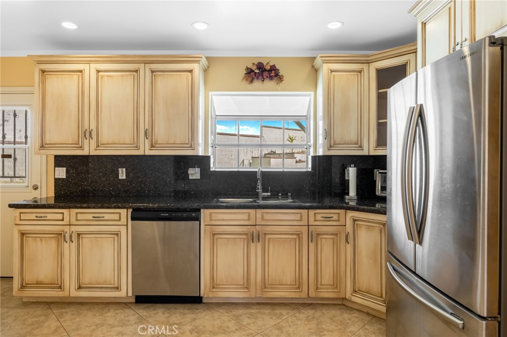 6249 Delfino Street Tujunga, CA 91042 - Photo 22 of 40 a kitchen with stainless steel appliances granite countertop a refrigerator and a sink