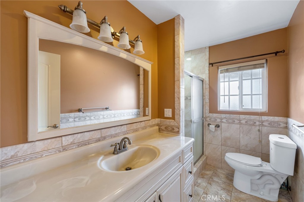 6249 Delfino Street Tujunga, CA 91042 - Photo 26 of 40 a bathroom with a toilet sink and mirror