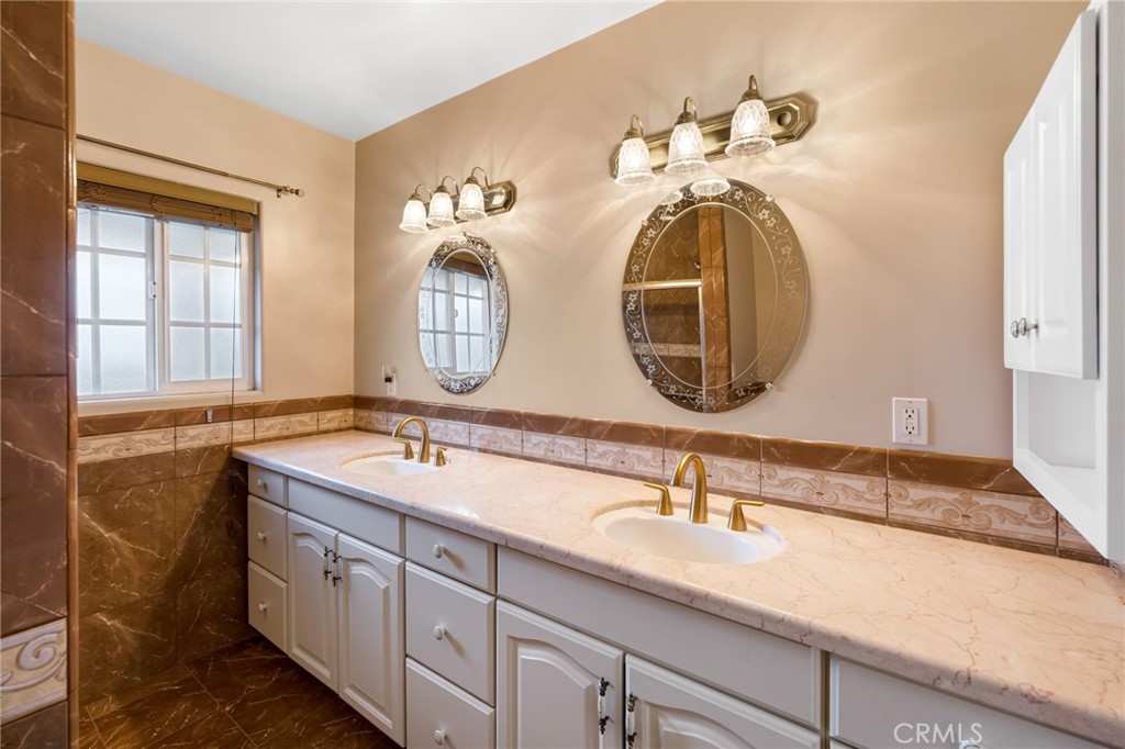 6249 Delfino Street Tujunga, CA 91042 - Photo 32 of 40 a bathroom with a double vanity sink and a mirror