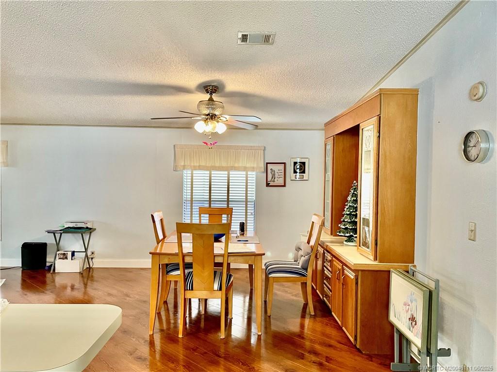 14524 Southwest Rake Drive Indiantown, FL 34956 - Photo 11 of 24 a view of a dining room with furniture and wooden floor