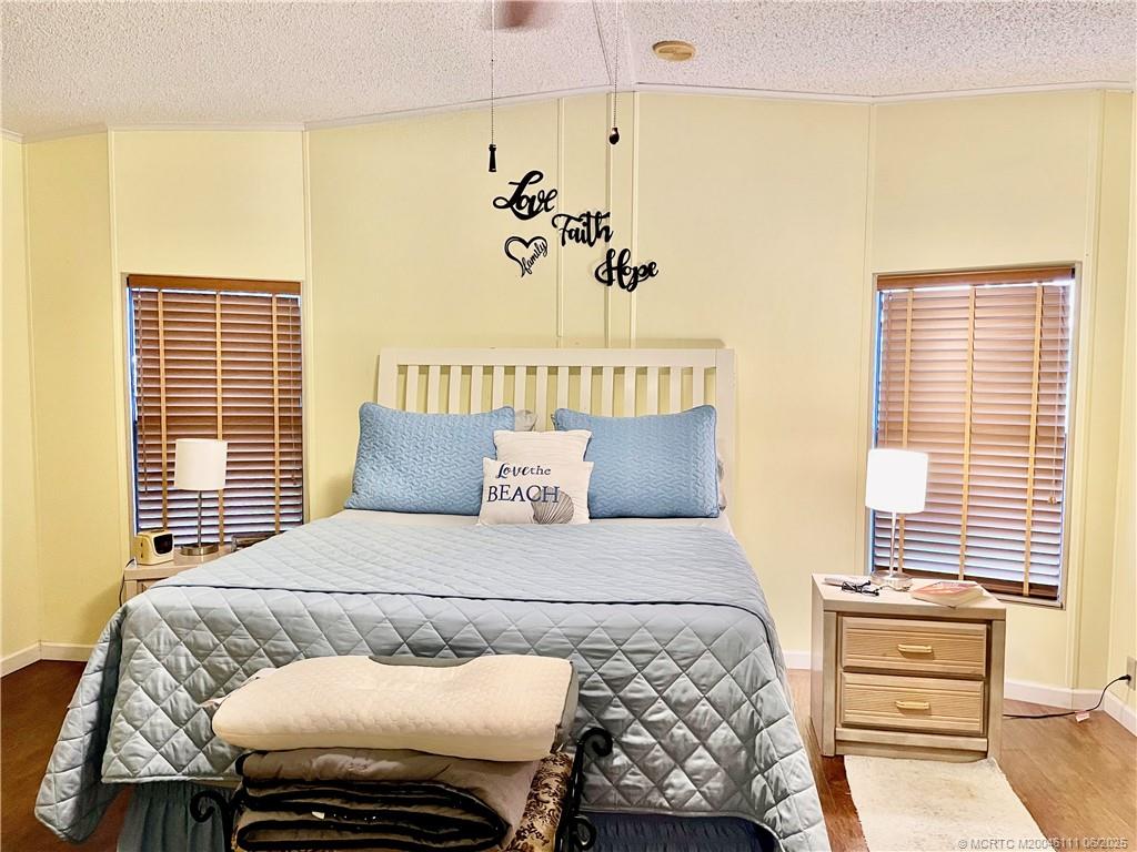 14524 Southwest Rake Drive Indiantown, FL 34956 - Photo 16 of 24 a bedroom with a bed and wooden floor