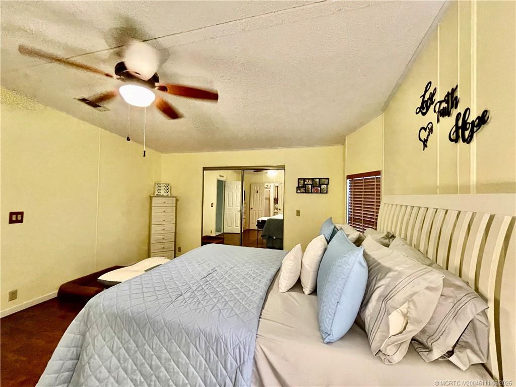 14524 Southwest Rake Drive Indiantown, FL 34956 - Photo 18 of 24 a bedroom with a bed and a chandelier