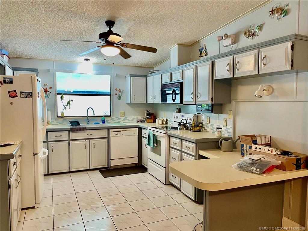 14524 Southwest Rake Drive Indiantown, FL 34956 - Photo 10 of 24 a kitchen with a sink appliances and cabinets
