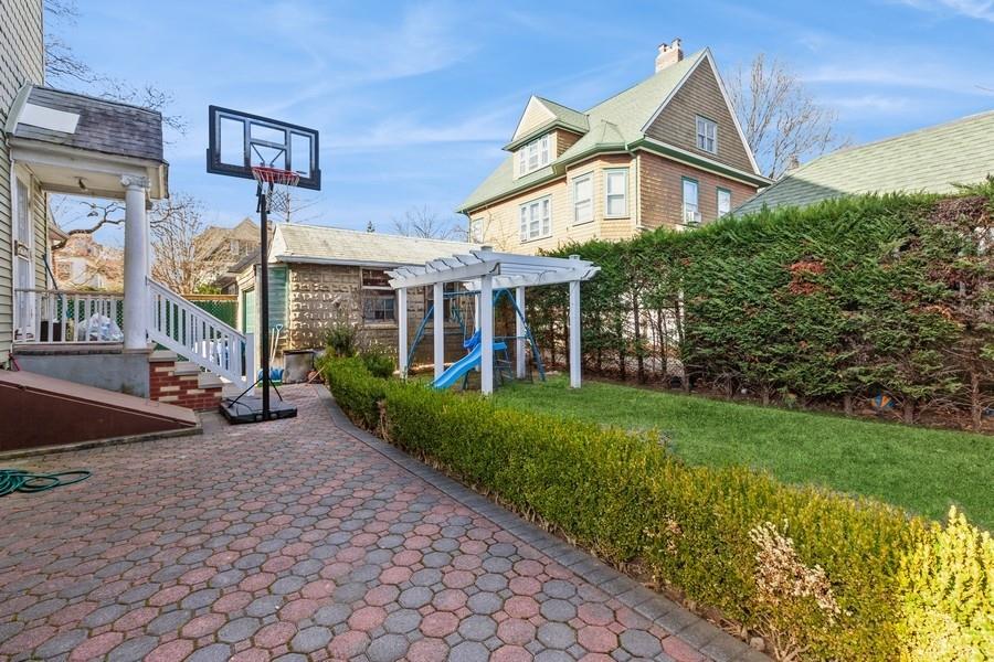 1205 Beverley Road Brooklyn, NY 11218 - Photo 29 of 34 a view of a white house with a large windows and a yard with plants