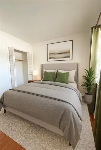 a bedroom with a large bed and a potted plant