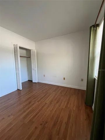 an empty room with wooden floor and entrance