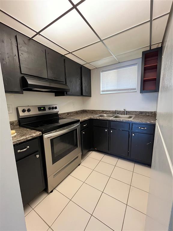 1014 East South Street, Unit 16 Orlando, FL 32801 - Photo 8 of 13 a kitchen with stainless steel appliances granite countertop a stove a sink and a microwave