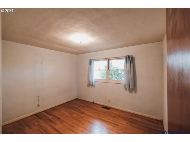 160 Tangent Street Lebanon, OR 97355 - Photo 16 of 32 an empty room with wooden floor and windows