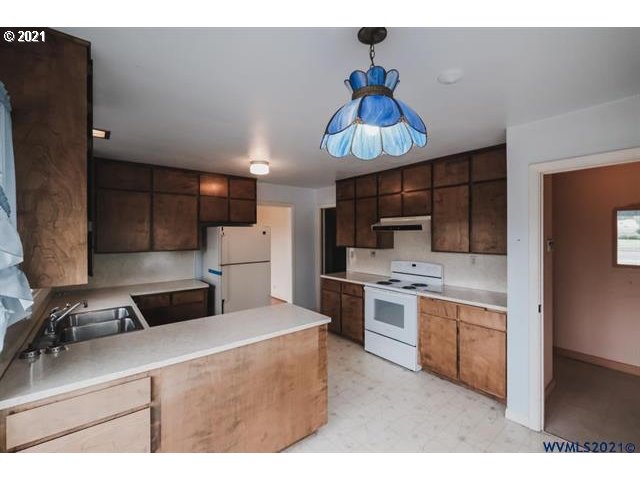160 Tangent Street Lebanon, OR 97355 - Photo 3 of 32 a kitchen with stainless steel appliances a sink a stove a refrigerator cabinets and a window