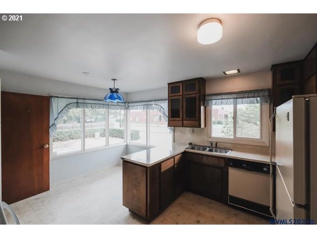 160 Tangent Street Lebanon, OR 97355 - Photo 5 of 32 a kitchen with granite countertop a sink and a refrigerator