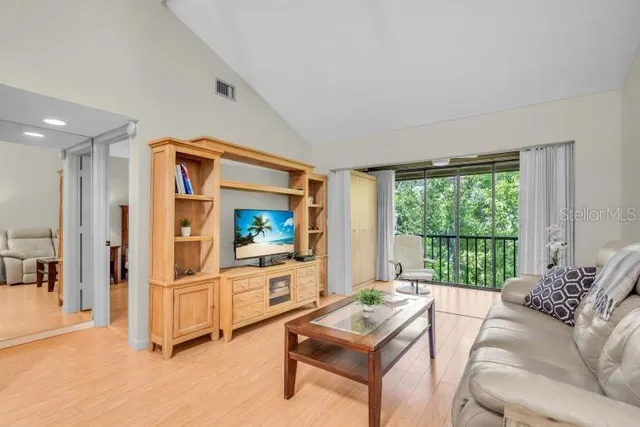 a living room with furniture a flat screen tv and a large window