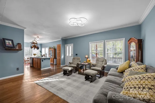 a living room with furniture large window and wooden floor