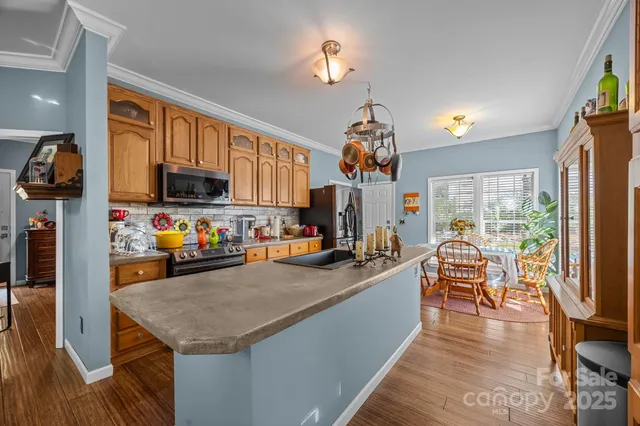 a kitchen with stainless steel appliances granite countertop a sink a stove and a refrigerator