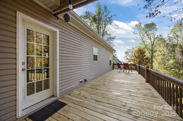 a view of a balcony with wooden floor and fence next to a large window