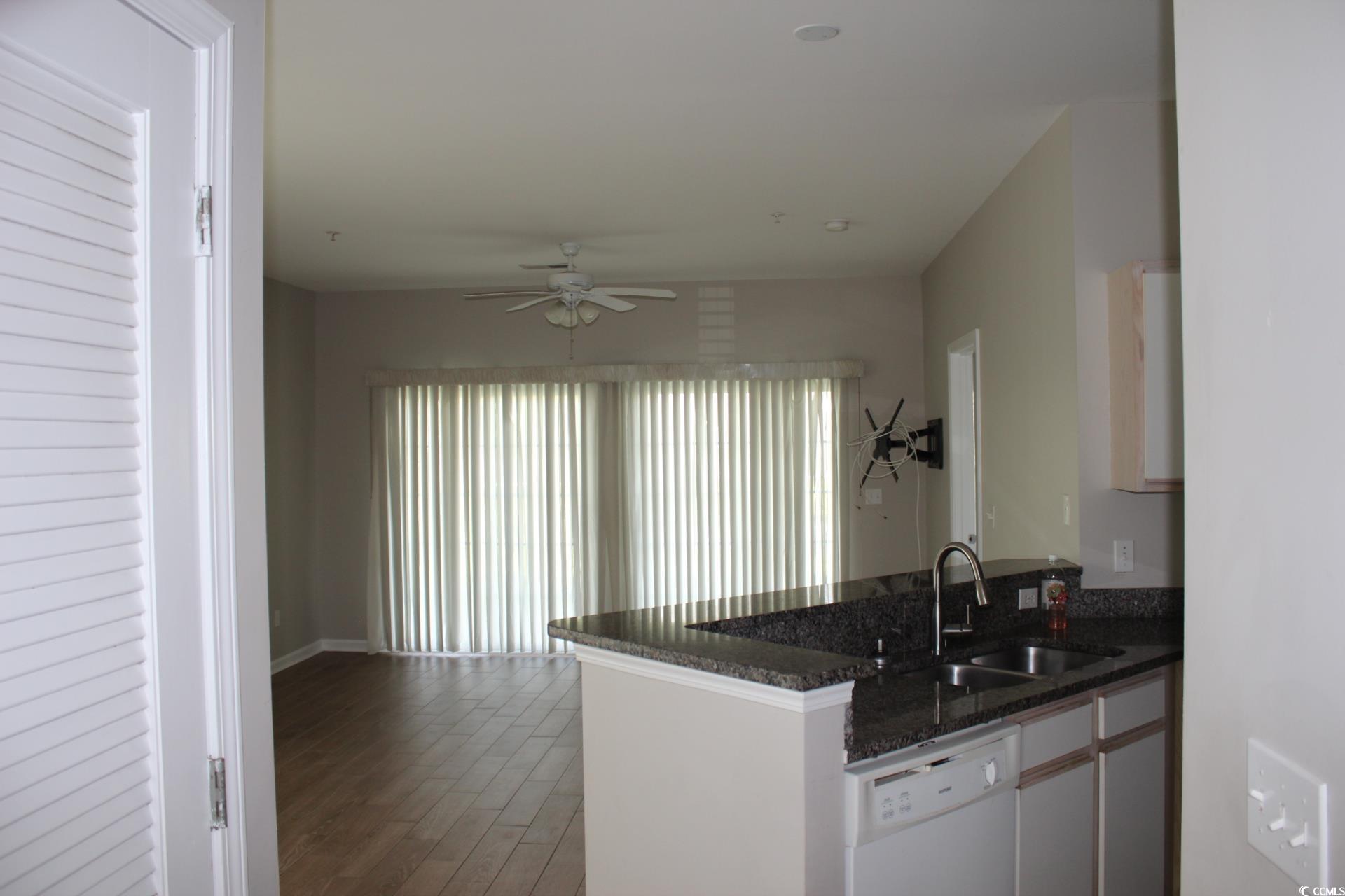 Kitchen featuring dishwasher, a ceiling fan, dark