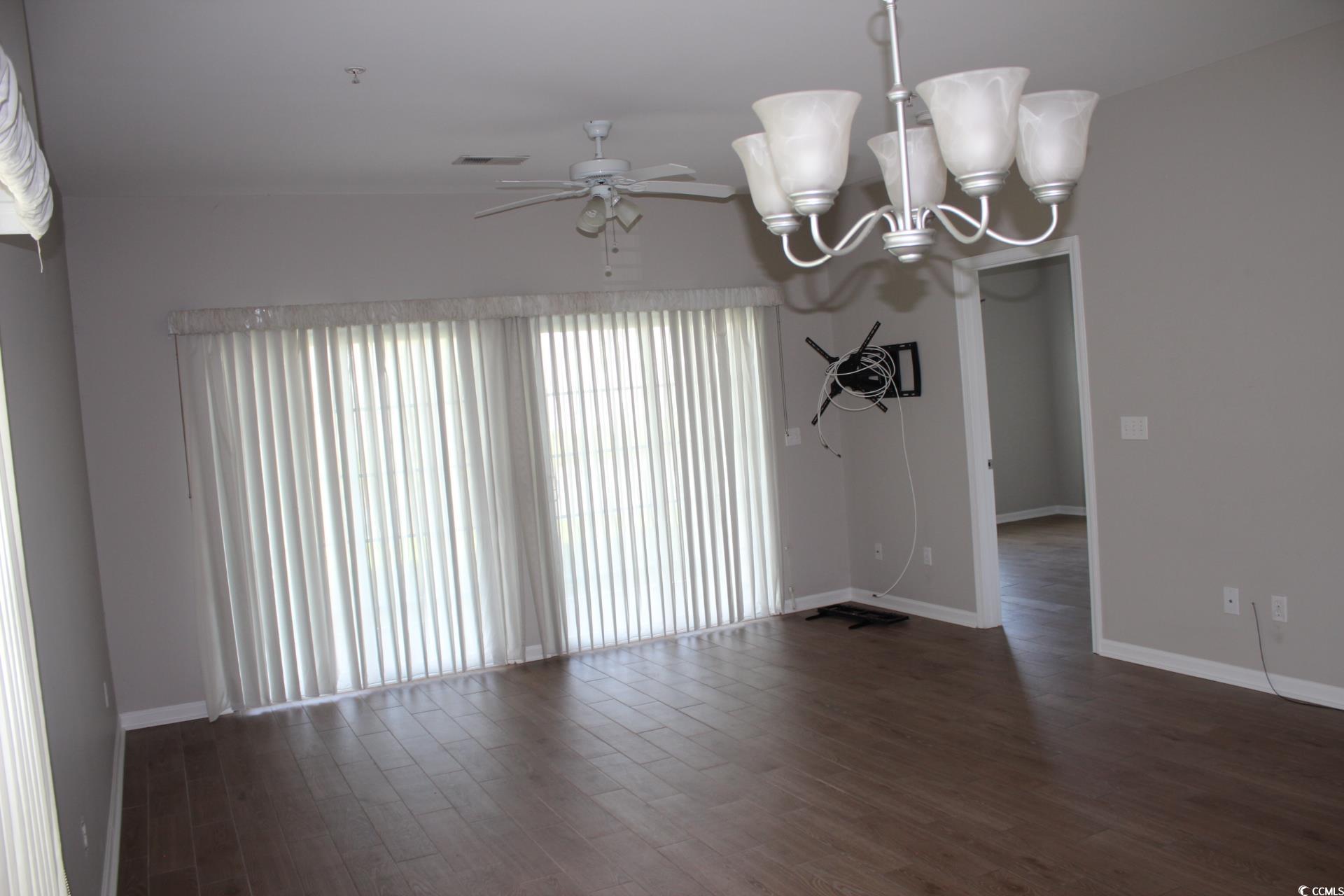 4928 Pond Shoals Court, Unit 101 Myrtle Beach, SC 29579 - Photo 3 of 4 Spare room with a chandelier, dark wood-style floo
