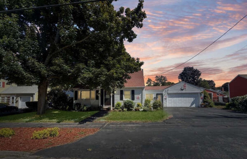 a front view of a house with a yard and a garage