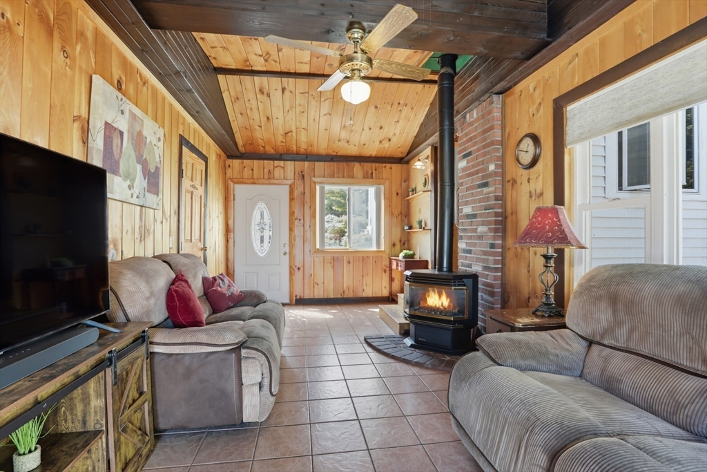72 Collins Street Danvers, MA 01923 - Photo 17 of 24 a living room with furniture a fireplace and a flat screen tv