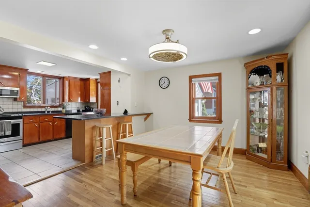 a kitchen with stainless steel appliances granite countertop a kitchen island a stove a table and chairs