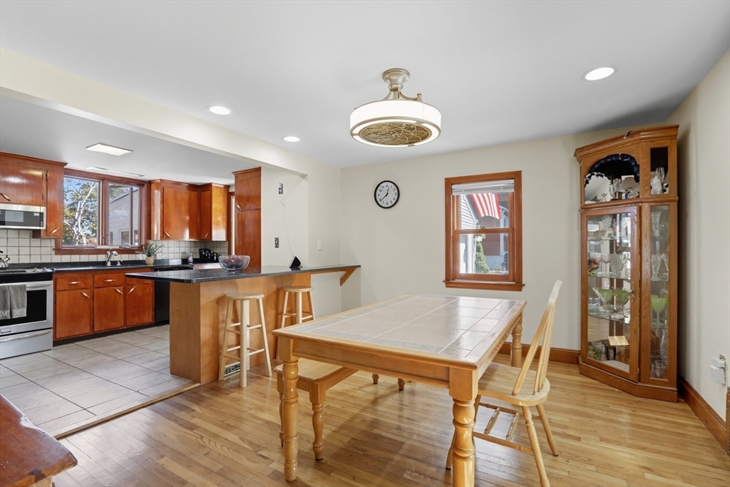 72 Collins Street Danvers, MA 01923 - Photo 4 of 24 a kitchen with stainless steel appliances granite countertop a kitchen island a stove a table and chairs