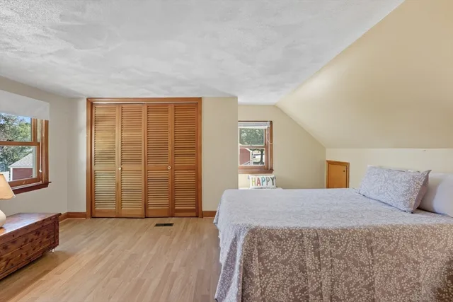 a bedroom with a balcony a bed and wooden floor