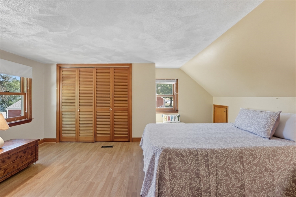 72 Collins Street Danvers, MA 01923 - Photo 9 of 24 a bedroom with a balcony a bed and wooden floor