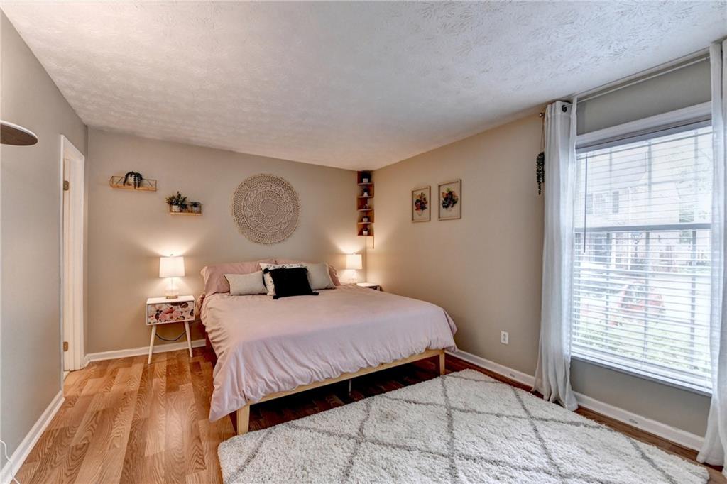 6700 Roswell Road, Unit 22B Atlanta, GA 30328 - Photo 21 of 34 a bedroom with a bed a window and a chandelier