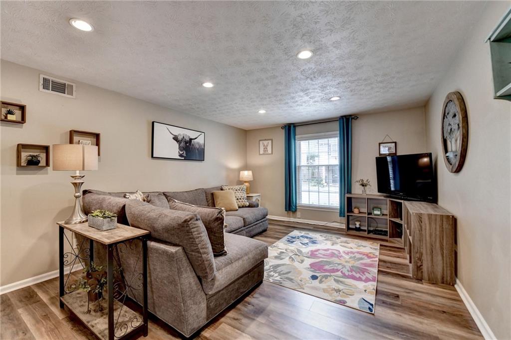 6700 Roswell Road, Unit 22B Atlanta, GA 30328 - Photo 3 of 34 a living room with furniture a flat screen tv and a window